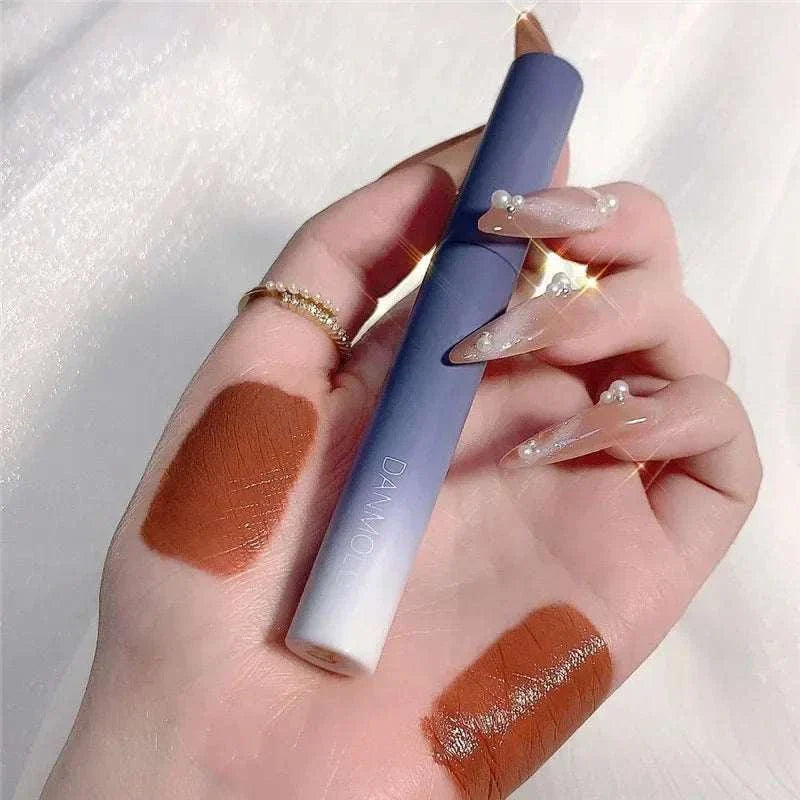 Matte Lipstick Set with smooth brown shades and sleek blue-white packaging held on hand with decorated nails