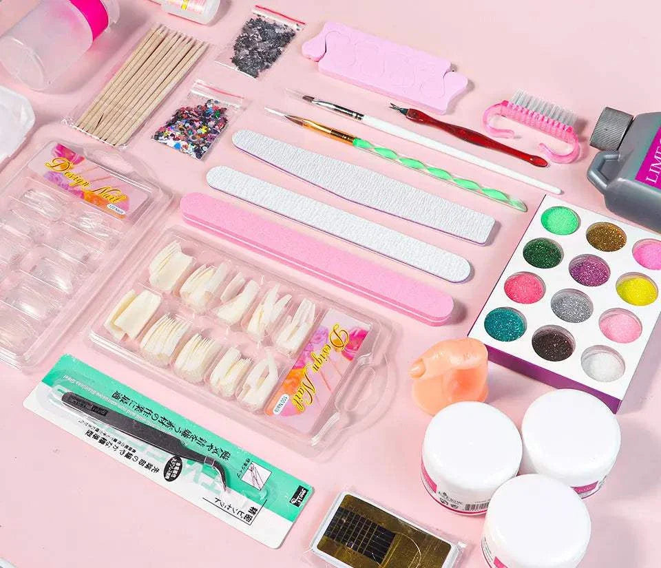 Nail acrylic powder and liquid monomer kit with nail tips, files, brushes, carving tools, glitter powders, and manicure accessories on pink background