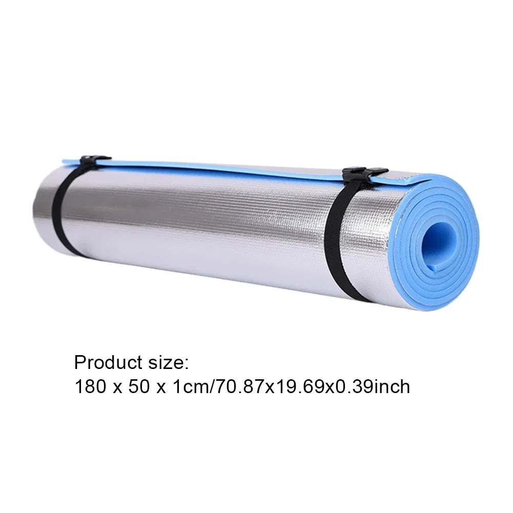 Rolled non-slip yoga mat with blue and silver color, secured with black straps, measuring 180x50x1cm.
