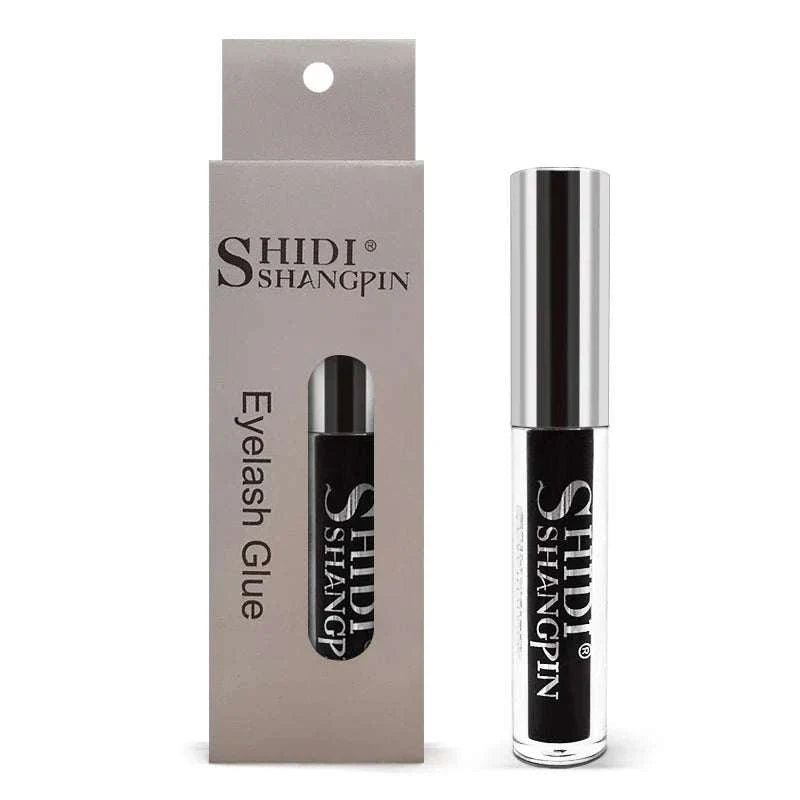 Black eyelash glue in a silver-capped clear tube with beige branded packaging