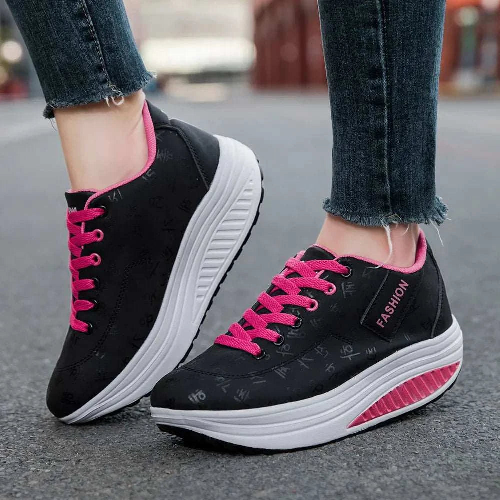 Black and pink breathable wedge heel sneakers with thick cushioned sole and lace-up closure worn with jeans