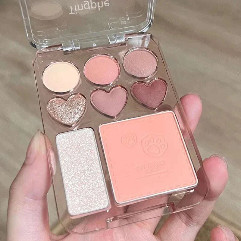 8-Color pink and orange eyeshadow palette with heart-shaped pans, blush, highlighter, and compact mirror.